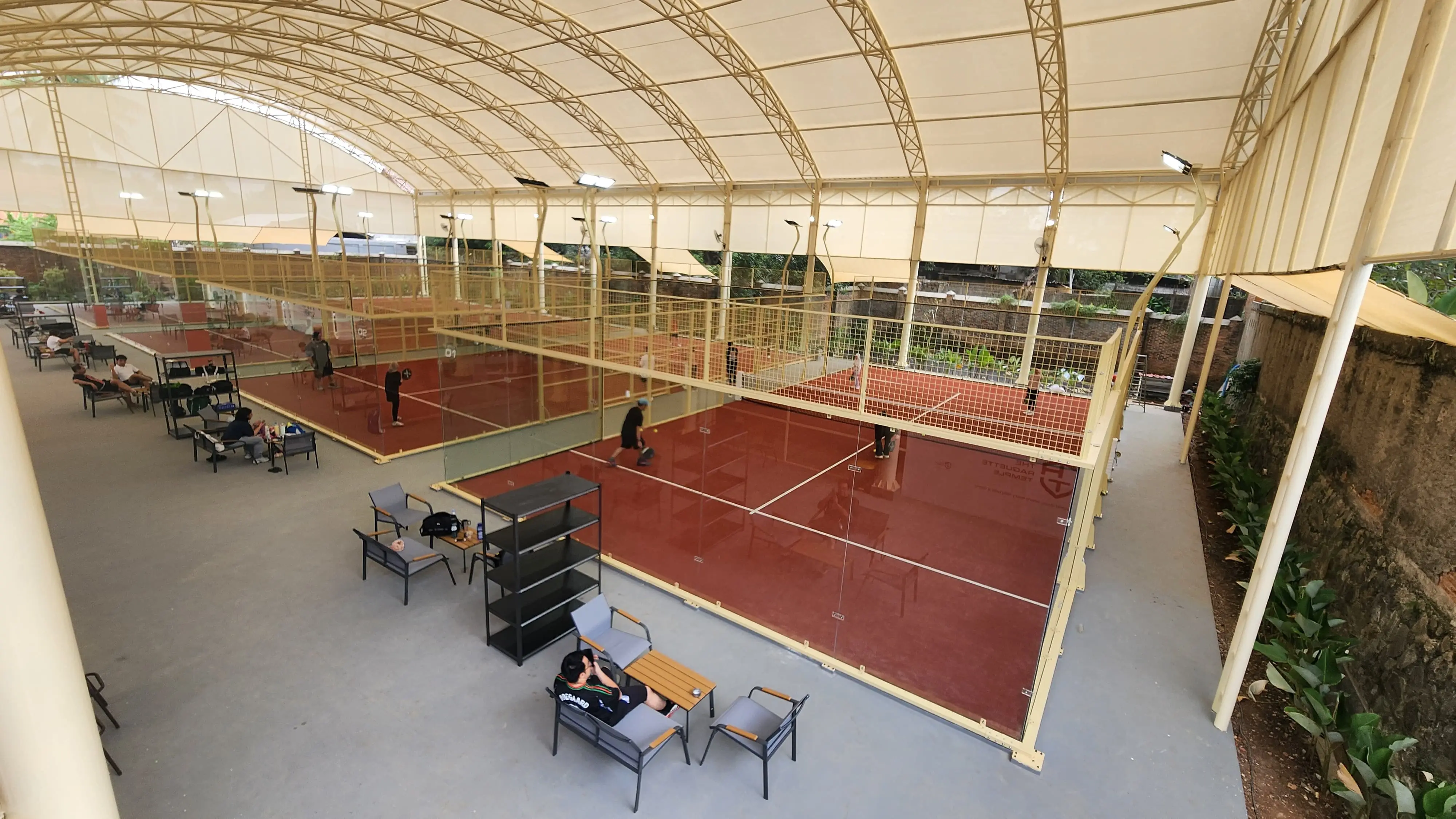 Visual referensi suasana bermain padel di lapangan outdoor